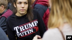 FILE - A woman wears a shirt reading "Trump Putin '16" while waiting for Republican presidential candidate Donald Trump to speak at a campaign event at Plymouth State University in Plymouth, N.H., Feb. 7, 2016.