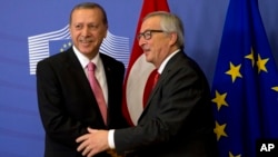 Turkish President Recep Tayyip Erdogan, left, is greeted by European Commission President Jean-Claude Juncker prior to a meeting at EU headquarters in Brussels, Belgium, Oct. 5, 2015. 