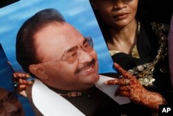 FILE - A supporter of Altaf Hussain, leader of the Muttahida Qaumi Movement, (MQM) holds his picture during a protest rally in Karachi, Pakistan, May 20, 2013.