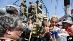 허리케인 피해를 입은 푸에르토리코 산후안에서 지난
24일 미국 주방위군 군인들이 수재민들에게 물과 음식을 지급하고 있다.