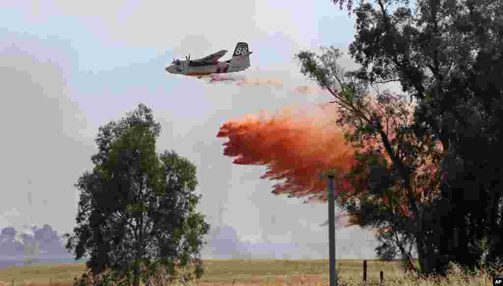 Un avion citerne décharge son contenu pour combattre un grand feu de brousse, 27 juillet, à Elverta, Californie.