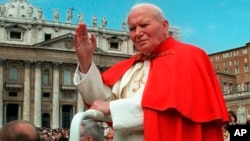 FILE - In this file photo taken on April 23 1997, Pope John Paul II waves to faithful as he crosses St. Peter's square at the Vatican.