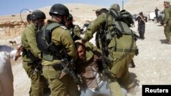 Israeli soldiers detain Palestinian manduring scuffles following EU diplomats' attempt to deliver aid to West Bank herding community of Khirbet al-Makhul, Sept. 20, 2013.