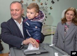 FILE - Leader of the Socialists Party, Igor Dodon, shown with his son Nikolai and wife Galina, casts his ballot, during the presidential elections in Chisinau, Moldova, Oct. 30, 2016. Dodon and second-place finisher Maia Sandu will face off in a November