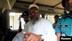 FILE - Bangladesh's Jamaat-e-Islami leader Abdul Quader Mollah talks from a police van after a war crimes tribunal sentenced him to life imprisonment in Dhaka. 