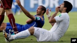 Uruguay's Luis Suarez holds his teeth after running into Italy's Giorgio Chiellini's shoulder during the group D World Cup soccer match between Italy and Uruguay at the Arena das Dunas in Natal, Brazil, Tuesday, June 24, 2014.