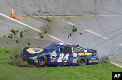 Grass flies in the air after Chase Elliott (24) spins during the NASCAR Daytona 500 Sprint Cup Series auto race at Daytona International Speedway in Daytona Beach, Florida, Sunday, Feb. 21, 2016.