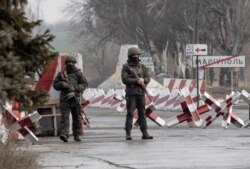 FILE - Ukrainian soldiers stand on a check-point close to the line of separation from pro-Russian rebels, Mariupol, Donetsk region, Jan. 21, 2022.