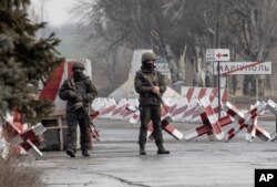 FILE - Ukrainian soldiers stand on a check-point close to the line of separation from pro-Russian rebels, Mariupol, Donetsk region, Jan. 21, 2022.