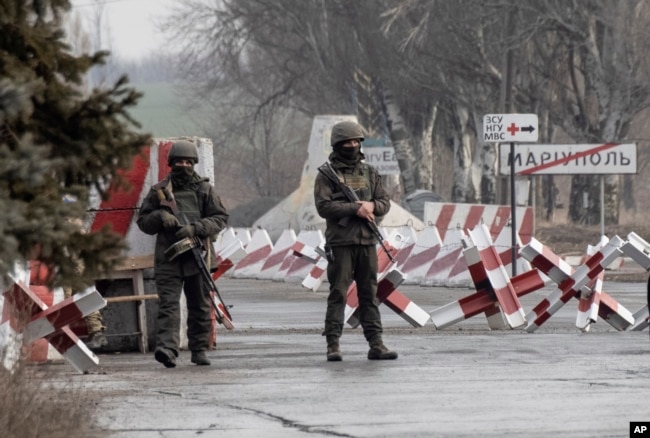 FILE - Ukrainian soldiers stand on a check-point close to the line of separation from pro-Russian rebels, Mariupol, Donetsk region, Jan. 21, 2022.