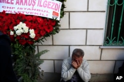 A man cries under a wreath during the funerals of victims on Saturday's bombing attacks, in Istanbul, Oct. 12, 2015.