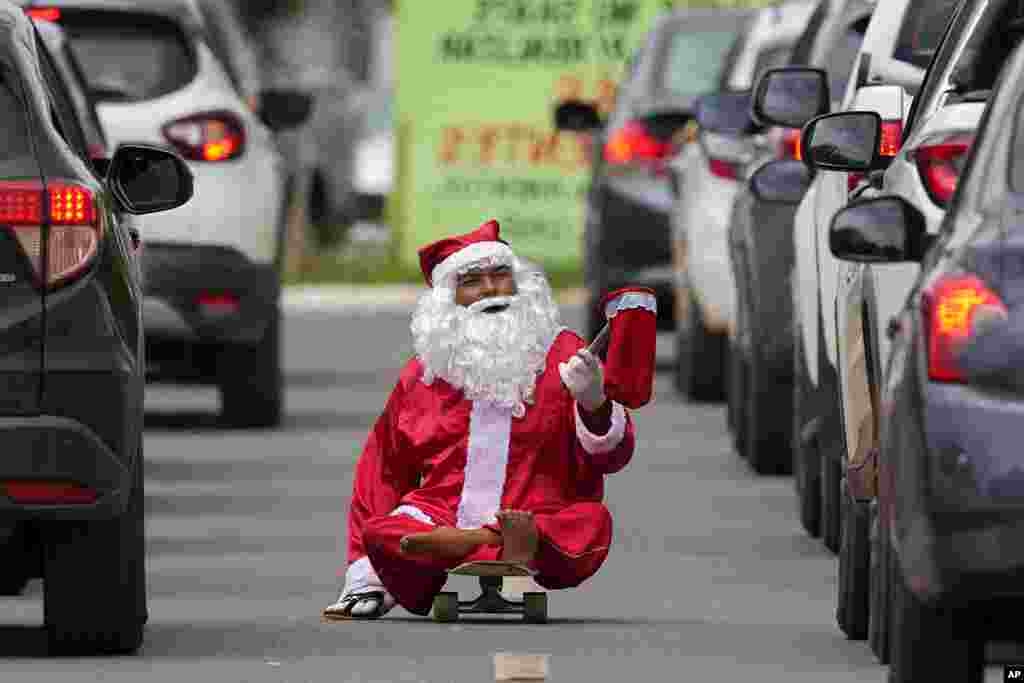 Jose Ivanildo, who lost the use of his legs due to infantile paralysis, uses a skate board as he begs for money at a traffic light dressed as Santa Claus in Brasilia, Brazil.