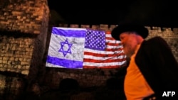 A picture taken on December 6, 2017 shows a giant US flag screened alongside Israel's national flag by the Jerusalem municipality on the walls of the old city.