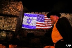 A picture taken on December 6, 2017 shows a giant US flag screened alongside Israel's national flag by the Jerusalem municipality on the walls of the old city.