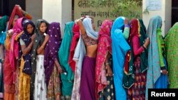 Women wait in a queue to cast their vote at polling station at Sirohi district in the desert Indian state of Rajasthan, April 17, 2014.