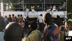 Les déplacés internes et les résidents déchargent un camion avec des biens de première nécessité, de la nourriture et des couvertures à Naunde, au nord du Mozambique, le 13 juin 2018.