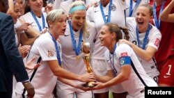 United States forward Abby Wambach (20) and United States defender Christie Rampone (3) hoist the trophy after defeating Japan in the final of the FIFA 2015 Women's World Cup at BC Place Stadium, July 5, 2015.