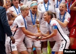 United States forward Abby Wambach (20) and United States defender Christie Rampone (3) hoist the trophy after defeating Japan in the final of the FIFA 2015 Women's World Cup at BC Place Stadium, July 5, 2015.