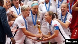 United States forward Abby Wambach (20) and United States defender Christie Rampone (3) hoist the trophy after defeating Japan in the final of the FIFA 2015 Women's World Cup at BC Place Stadium, July 5, 2015.