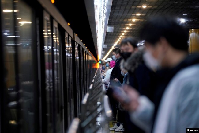 春节假期后，上海地铁站戴着口罩的人群在等车。（2020年2月10日）