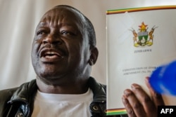 FILE: Zimbabwe National Liberation War Veterans Association (ZNLWVA) Secretary-general Victor Matemadanda holds up the country's constitution at a press conference in Harare on November 15, 2017.