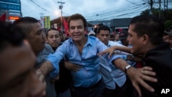 Opposition Alliance presidential candidate Salvador Nasralla greets supporters in front of the Supreme Electoral Tribunal in Tegucigalpa, Honduras, Monday, Nov. 27, 2017. Early results from Honduras' presidential election Monday showed Nasralla with a surprise lead over President Juan Orlando Hernandez, both of whom had claimed victory. (AP Photo/Rodrigo Abd)