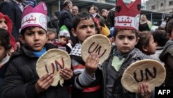 Anak-anak Palestina menggenggam lempengan roti dalam unjuk rasa memprotes pemotongan bantuan di kantor PBB, di Khan Yunis di bagian selatan Jalur Gaza, 28 Juni 2018.