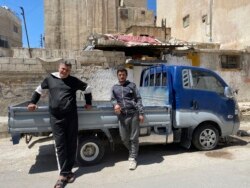 In this April 13, 2020, photo, brothers Mohammed and Khalil Yousef pose in front of a pickup truck in the Palestinian refugee camp of al-Wehdat in Jordan’s capital of Amman. (AP Photo/Omar Akour)