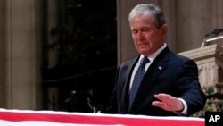 5일 워싱턴에서 국장으로 거행된 조지 H.W. 부시 전 대통령 장례식에서 아들 조지 W. 부시 전 대통령이 아버지의 관에 손을 얹고 있다.