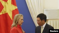 Menlu AS Hillary Clinton (kiri) berbicara dengan Menlu Vietnam, Pham Binh Minh dalam kunjungannya di Hanoi (10/7).