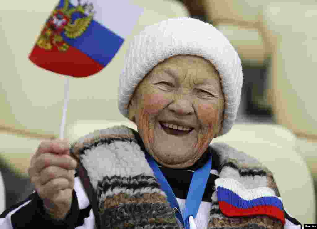 Pendukung Rusia mengibarkan bendera nasional sebelum dimulainya pertandingan speed skating 5.000 meter di Arena Adler, Sochi, 19 Februari 2014.