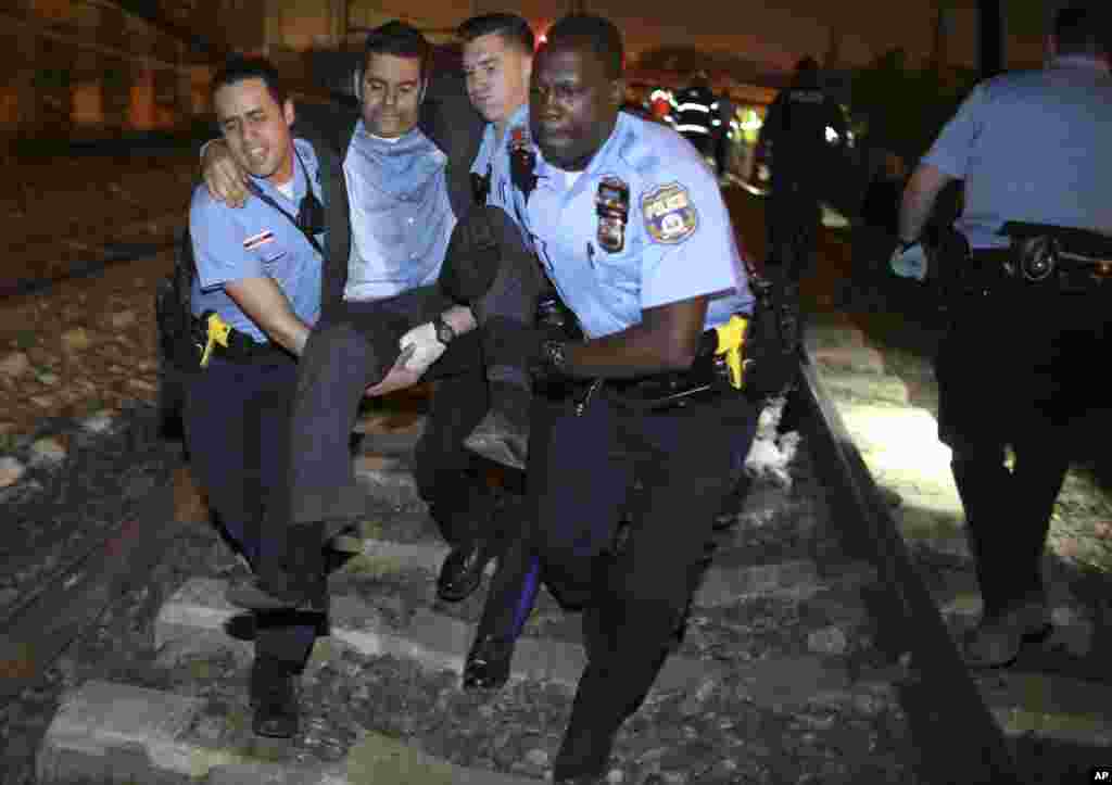 Emergency personnel help a passenger at the scene of a train wreck, in Philadelphia, May 12, 2015.