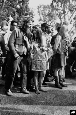 FILE: A woman looks at her friend's necklace, which tells which group of hippies he belongs to in San Francisco's Golden Gate Park on August 8, 1967.(AP Photo)