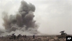 A dust cloud is seen following the explosion of a missile, outside the strategic oil port of Brega, Libya, April 7, 2011.