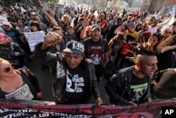Protesters from an anarchist group shout slogans as they march against fuel price hikes in Mexico City, Jan. 9, 2017.