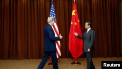 Menteri Luar Negeri China Wang Yi (kanan) menyambut Menteri Luar Negeri AS John Kerry dalam kunjungan di Beijing (14/2). (Reuters/Diego Azubel)