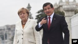 Perdana Menteri Turki Ahmet Davutoglu, kanan, berbicara dengan Kanselir Jerman Angela Merkel, kiri, ketika bertemu di kantornya di Istana Dolmabahce di Istambul, 18 Oktober 2015. 