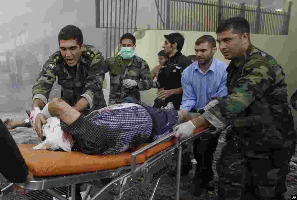 Lebanese army soldiers help an injured man after two explosions near the Iranian embassy in Beirut, Nov. 19, 2013.