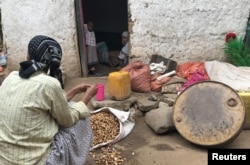 A woman prepares groundnuts outside her home in a neighborhood where ethnic Oromos live in Harar, Ethiopia, July 22, 2018.