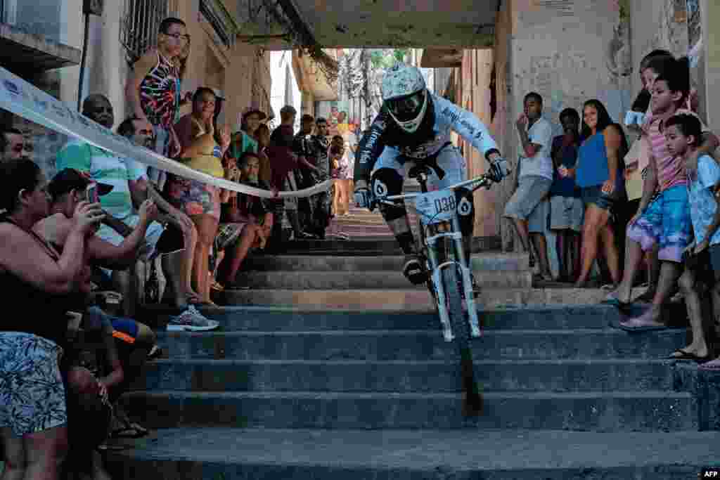 A competitor goes down steps of an alley during the Favelas Mountain Bike circuit at Turano shantytown in Rio de Janeiro, Brazil.