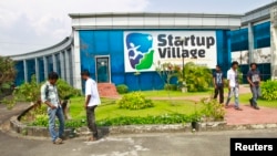 FILE - Employees stand outside the Start-up Village in Kinfra High Tech Park in the southern Indian city of Kochi.