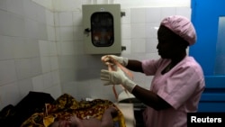 FILE - A midwife prepares to measure a newborn baby at the general hospital in Man, western Ivory Coast, July 4, 2013. 