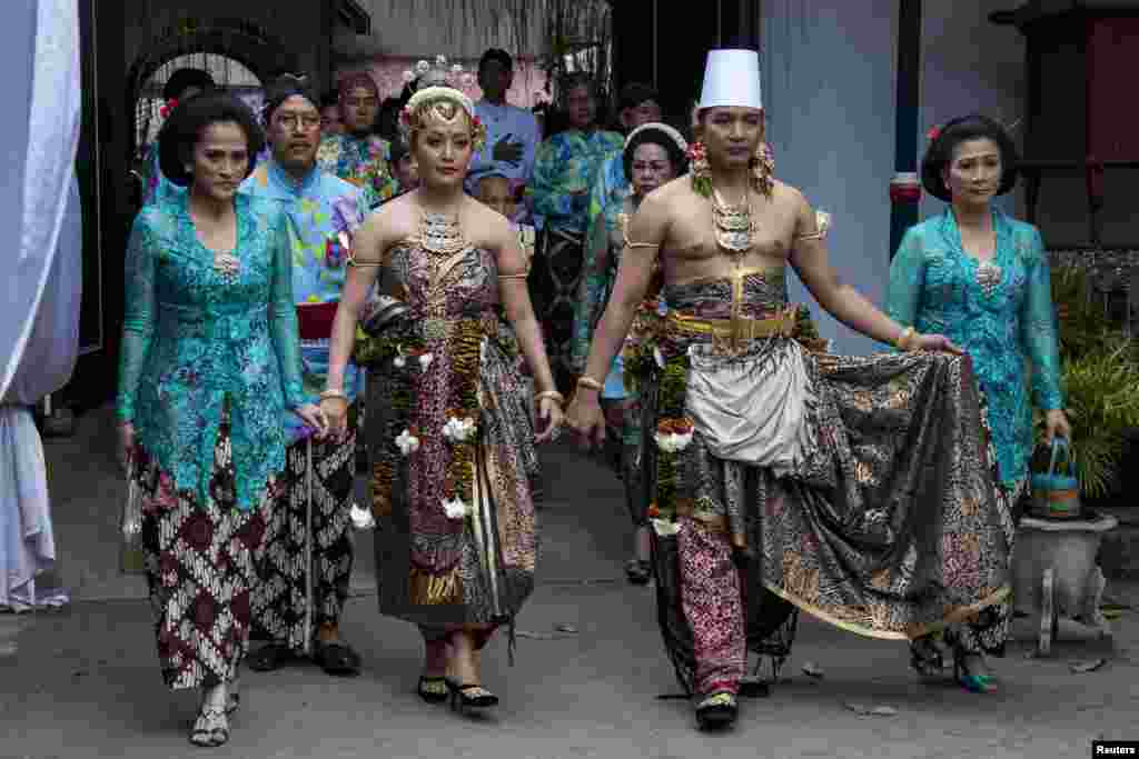 Groom Kanjeng Pangeran Haryo Notonegoro (2nd R) and his bride Gusti Kanjeng Ratu Hayu (2nd L), the daughter of Sultan Hamengkubuwono X, walk after their wedding ceremony at Kraton in the old city of Yogyakarta, Indonesia. 