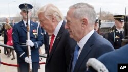 FILE - U.S. Defense Secretary Jim Mattis, right, and U.S. President Donald Trump walk into the Pentagon in Washington.