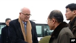 Stephen Bosworth (C), US special envoy to North Korea, shakes hands with an unidentified North Korean official upon his arrival at Pyongyang airport, 08 Dec 2009
