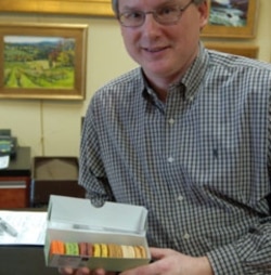 Rande Januss with a box of macarons at his Wine Cabinet store in Reston, Virginia