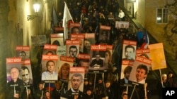 FILE - People holding placards protest at a rally in Prague, Czech Republic, Nov. 22, 2021, to decry the government’s restrictions on unvaccinated people as new infections soared in the European Union nation. The words ZRADCE NARODA on the placards read: "Betrayer of the nation."