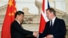 资料照：2015年10月21日时任英国首相卡梅伦(右)与中国国家主席习近平在英中商业峰会上握手。