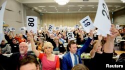 Le chef de file du Conseil norvégien Eglise Kristin Gunleiksrud Raaum, en rouge, et le président du conseil diocésain d'Oslo Gard Sandaker-Nielsen, à droite, votent sur une proposition visant à permettre le mariage de même sexe au sein de l'Eglise de Norvège, à Oslo, le 11 Avril 2016. (REUTERS/Ole Martin Wold)