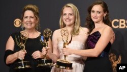 Ann Dowd, from left, winner of outstanding supporting actress in a drama series, Elisabeth Moss, winner of outstanding lead actress in a drama series, and Alexis Bledel, winner of outstanding guest actress in a drama for "The Handmaid's Tale" pose at the 69th Primetime Emmy Awards, Sept. 17, 2017, Los Angeles.